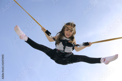 Photo: Young girl playing on bungee trampoline Young girl playing on bungee trampoline