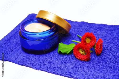 Foto: Creme mit Blüte auf Badetuch Creme mit Blüte auf Badetuch