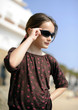 Photo: Young girl adjusting sunglasses Young girl adjusting sunglasses