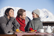 Couple and daughter eating on balcony at ski resort