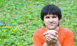 Smiling man drinking coffee on nature. Copy space
