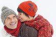 Young man giving his girlfriend piggyback in snow