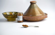 A Spoonful of Harissa Paste In Front of a Tagine, Jar and Dish