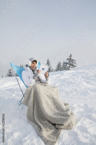 Photo: Young woman reading in snow Young woman reading in snow