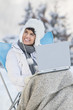 Young woman using laptop computer in snow