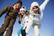 Couple and daughter in ski wear smiling at camera