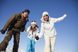 Couple and daughter in ski wear smiling at camera