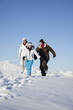 Couple and daughter in ski wear running in snow