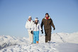 Couple and daughter in ski wear walking in snow