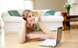 Happy woman using a laptp lying on the floor