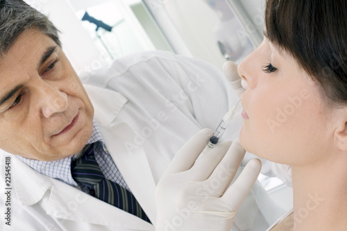 Photo: young woman receiving an injection of botox from a doctor young woman receiving an injection of botox from a doctor