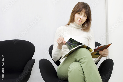 Photo: young caucasian woman sitting in the waiting room for doctors young caucasian woman sitting in the waiting room for doctors