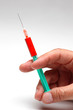 Arzt hält Spritze in der Hand mit Blut