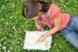 adventure girl with a map of the city lies on the grass