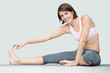 Cute woman doing stretching exercise on a yoga mat