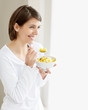 Pretty female eating a bowl of healthy cut fruits