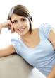 Lovely young female smiling on the couch against white