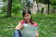 adventure girl with a map of the city lies on the grass