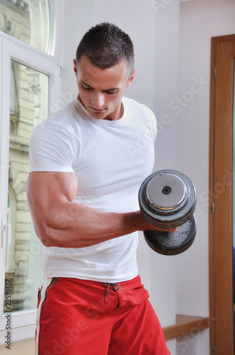 Photo: Powerful muscular man lifting weights Powerful muscular man lifting weights