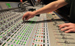 Audio engineer operating mixing console Audio engineer operating mixing console