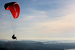Paraglider flying over Norwegian coastal landscape