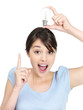 Cute casual female holding a light bulb over head