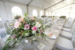 A table setup for a wedding reception in a big tent