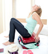 Laughing woman trying to close her suitcase Laughing woman trying to close her suitcase