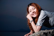 Beautiful young woman on the beach at sunset .