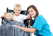 Nice female doctor carrying adorable little boy with his teddy b