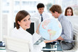 Confident businesswoman holding a globe