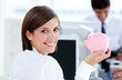 Happy businesswoman holding a piggybank