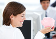 Smiling businesswoman holding a piggybank