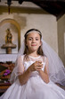 Photo: Young girl in church wearing first communion dress Young girl in church wearing first communion dress