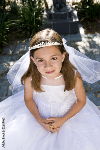 Photo: Young girl in white dress and veil outdoors Young girl in white dress and veil outdoors