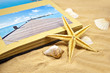 Seestern, Muscheln, Sand und Fotoalbum