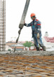 builder worker pouring concrete into form