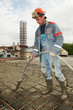 builder worker pouring concrete into form