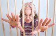 Mädchen traurig hinter Gittern