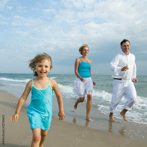 Photo: Happy family running at the beach Happy family running at the beach