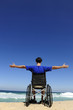 man in wheelchair enjoying summer vacation on the  beach