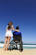 Photo: woman and husband in wheelchair on the beach woman and husband in wheelchair on the beach