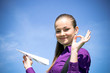 Young caucasian girl with paper plane in the hand