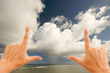 Hands Framing Dramatic Clouds over Tropical Shoreline Hands Framing Dramatic Clouds over Tropical Shoreline