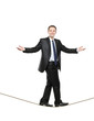 A businessman walking on a high tightrope A businessman walking on a high tightrope