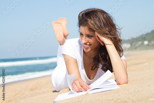 young indian woman reading on beach young indian woman reading on beach