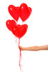 Photo: Hand holding heart ballons Hand holding heart ballons