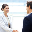 Beautiful female executive shaking hands with her coworker