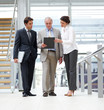 Businesspeople discussing reports in a office corridor