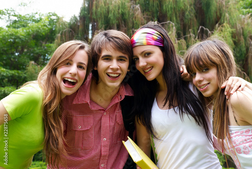 Photo: Portrait happy young students in park Portrait happy young students in park